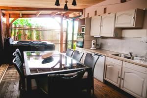 a kitchen with a table and chairs and a sink at Villa Le Colonial Zen - T4 à 5 mn Aéroport in Sainte-Marie +14 photos