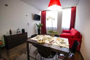 ヴェローナにあるItalianflat - Arena di Verona Apartmentsのリビングルーム(テーブル、赤いソファ付)