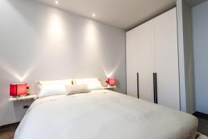 sypialnia z dużym białym łóżkiem z 2 czerwonymi lampami w obiekcie Italianflat - Arena di Verona Apartments w Weronie