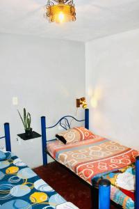 a bedroom with two beds and a chandelier at Hostal Música y Arte in San Agustín