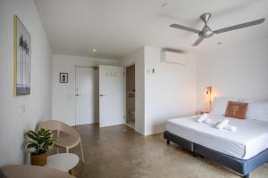 een slaapkamer met een bed en een plafondventilator bij Boutique Hotel JT Curaçao in Willemstad