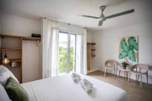 a bedroom with a white bed and a window at Boutique Hotel JT Curaçao in Willemstad