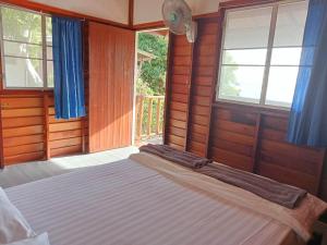 ein Schlafzimmer mit einem Bett in einem Zimmer mit Fenstern in der Unterkunft The Ocean Phangan Homestay in Haad Rin