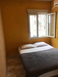 Cama en habitación con ventana en MilanG, en Madrid