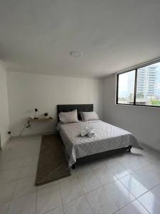 1 dormitorio con 1 cama en una habitación con ventana en Acogedor apto para 8 zona buenavista, en Barranquilla