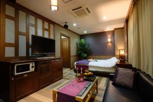ein Hotelzimmer mit einem Bett und einem Wohnzimmer in der Unterkunft 艶横浜町田店 adult only in Yokohama