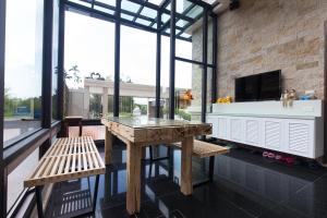 a kitchen with a table and benches and a large window at Creekside No.22 B&B in Jiali