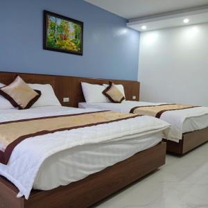 two beds in a room with blue walls at Bảo An hotel Đảo Quan Lạn in Làng Liễu