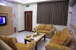 a living room with couches and a tv at Moon Villa in Zhongpu