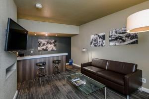 a living room with a couch and a bar at Lions Gate Hotel in Sacramento