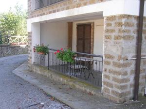 a balcony with a table and chairs on a building at Farmhouse with pool in an area with history nature and art in Bagnoregio