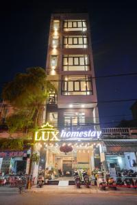クイニョンにあるLux Quy Nhon Homestayの看板が目の前にある高層ビル