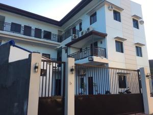 a white building with a gate and a fence at Donadel Hometel in Iloilo City