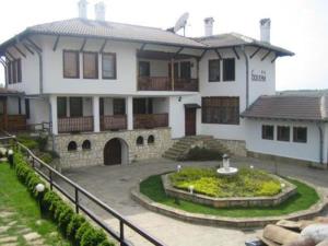 a large white house with a courtyard in front of it at Bohemi Hotel in Arbanasi