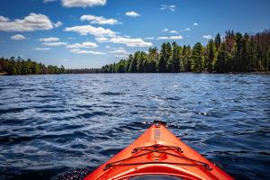 un kayak orange sur un grand plan d'eau dans l'établissement Perfect 3 bedroom waterfront muskoka cottage, à Parry Sound