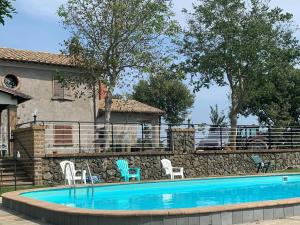 バニョレージョにあるFarmhouse in Bagnoregio with Private Pool ideal for groupsの石壁の隣に椅子付きのスイミングプール