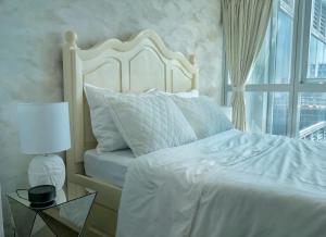 ein Schlafzimmer mit einem weißen Bett und einem Fenster in der Unterkunft Uptown BGC Taguig - One Bedroom in Manila