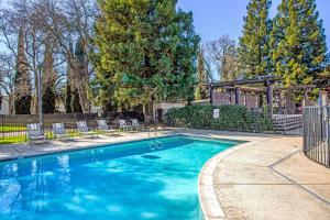 a swimming pool with chairs and a gazebo at Lions Gate Hotel in Sacramento