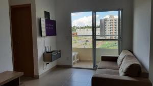 a living room with a couch and a large window at Apto novo Parque Mosaico in Manaus