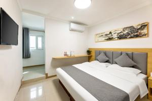 a bedroom with a bed and a flat screen tv at Happy Dragon Hotel National Art Museum Metro Forbidden City in Beijing
