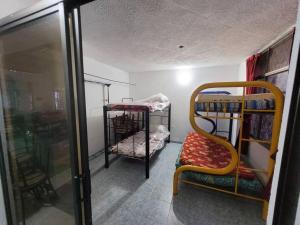 a room with two bunk beds and a chair at Casa vacacional para la familia in Carmen de Apicalá