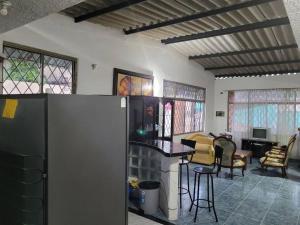 a kitchen with a refrigerator and a living room at Casa vacacional para la familia in Carmen de Apicalá