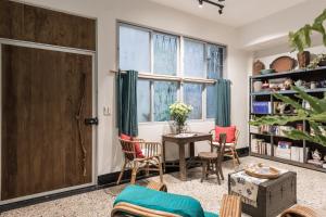 a living room with a table and chairs and a window at Seamoon House in Tainan