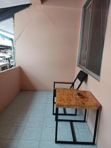 a wooden table and a chair in a room at Kalisa House@Soi welcome in Jomtien Beach