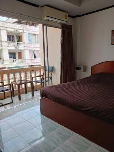 1 dormitorio con cama y vistas a un balcón en Kalisa House@Soi welcome en Jomtien Beach