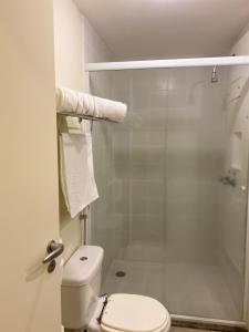 La salle de bains est pourvue de toilettes et d'une douche en verre. dans l'établissement Hotel Aeroporto de Congonhas - Flat, à São Paulo