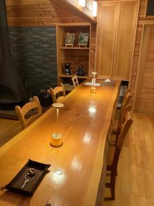 un grande tavolo in legno in una stanza con sedie di 貸し別荘 Key of Private Villa 'ムササビハウス' a Kita-karuizawa