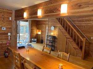 a dining room with a wooden table and a staircase at 貸し別荘 Key of Private Villa 'ムササビハウス' in Kita-karuizawa