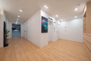 a large room with white walls and wooden floors at The Hyoosik Aank Hotel Cheonan Station 1st Branch in Cheonan