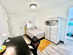 Dormitorio pequeño con cama y mesa en Micro Studio Apartment 10 Minutes Walk to University of Washington en Seattle