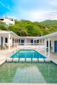 una piscina con sedie a sdraio di fronte a un edificio di Casa Toboro a Taganga