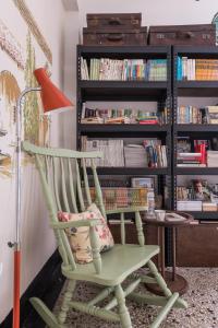 a green rocking chair in front of a book shelf at Seamoon House in Tainan +22 photos