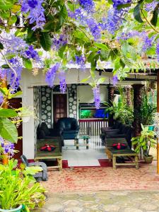 a living room with purple flowers hanging from a tree at Pearl White House in Udawalawe