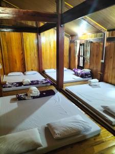 Habitación con 4 camas y paredes de madera. en Nặm Pé Homestay en Bak Kan