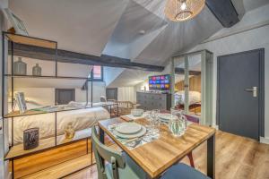 a dining room with a table and a bed at Le Strasbourg - Centre ville - Climatisation in Grenoble