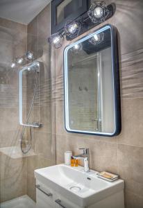 uma casa de banho com um lavatório, um espelho e um chuveiro em Le Strasbourg - Centre ville - Climatisation em Grenoble