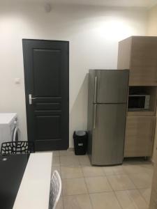 a kitchen with a black door and a refrigerator at Sci ZLR in Saint-Étienne