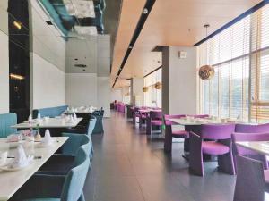 una sala da pranzo con tavoli bianchi e sedie viola di Hua Hotel -Nanshan Technology Park a Shenzhen