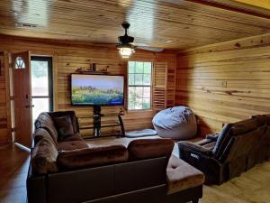 a living room with a couch and a flat screen tv at Quiet cabin near Enid Lake in Enid