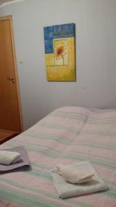 un letto con due asciugamani e un dipinto sul muro di Tana Vertshus a Bånjakas