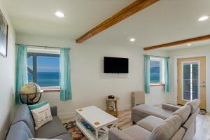 un soggiorno con un divano e una TV di Breathtaking Oceanview! by OceanviewHotTubs Monthly Minimum a Shelter Cove