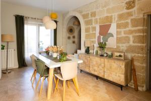 a dining room with a white table and chairs at MAISON BELLEVUE DE SAGRIES in Sagriès