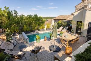 an outdoor patio with a table and chairs and a pool at MAISON BELLEVUE DE SAGRIES in Sagriès