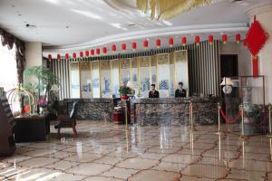 dos hombres parados en un bar en el vestíbulo de un hotel en Hengna International Hotel, en Yiwu