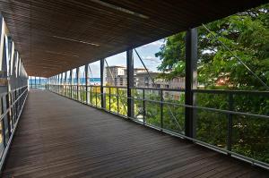 a wooden walkway with a view of a building at '18th in the Clouds' CBD Resort Living with Pool in Darwin