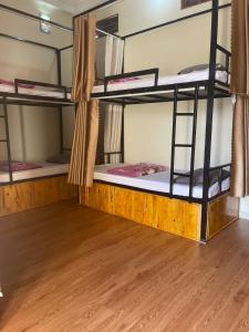 a room with three bunk beds in a dorm at HG Hostel and Motorbikes in Ha Giang